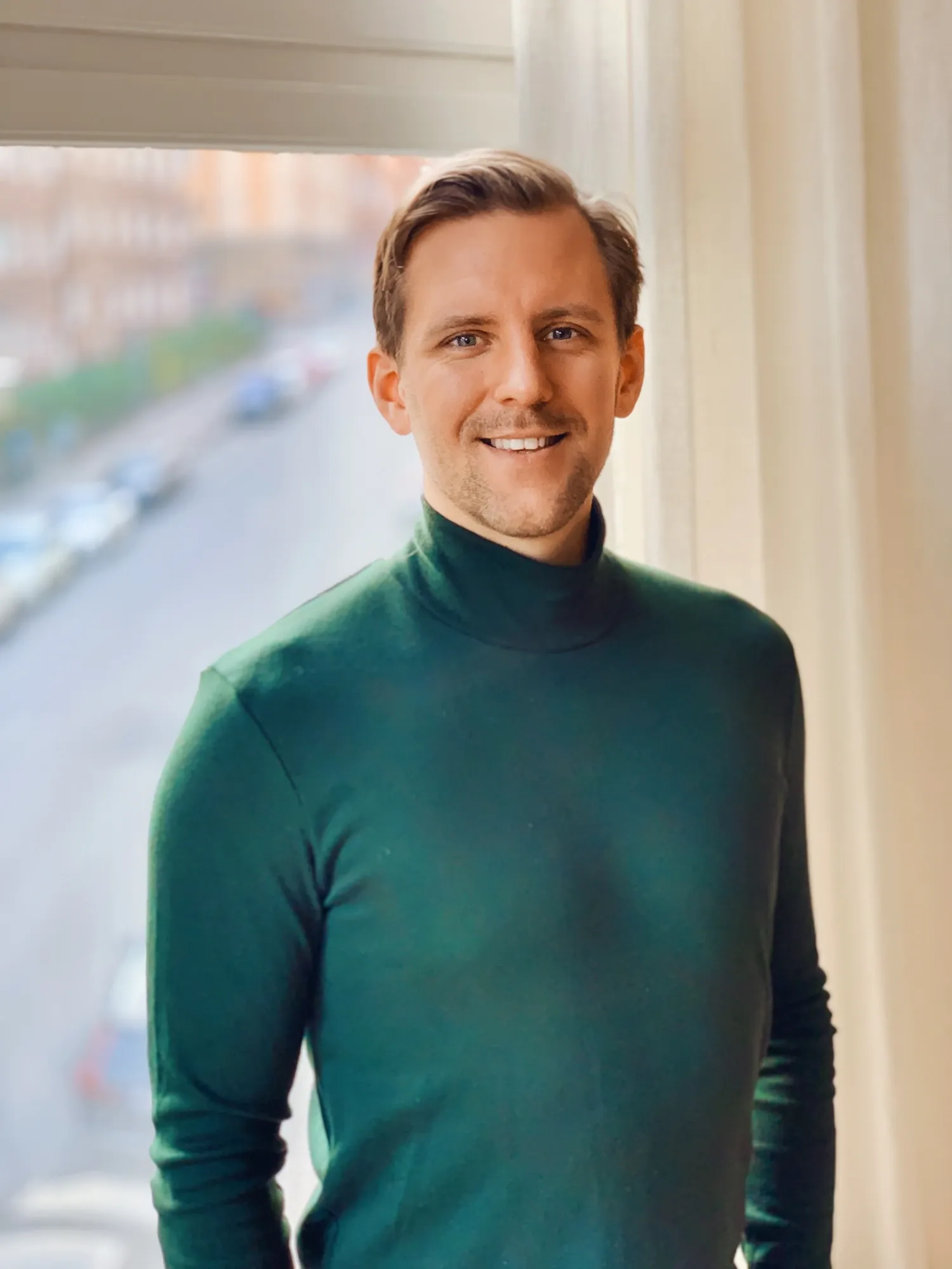 Portrait of a man wearing a green turtleneck.