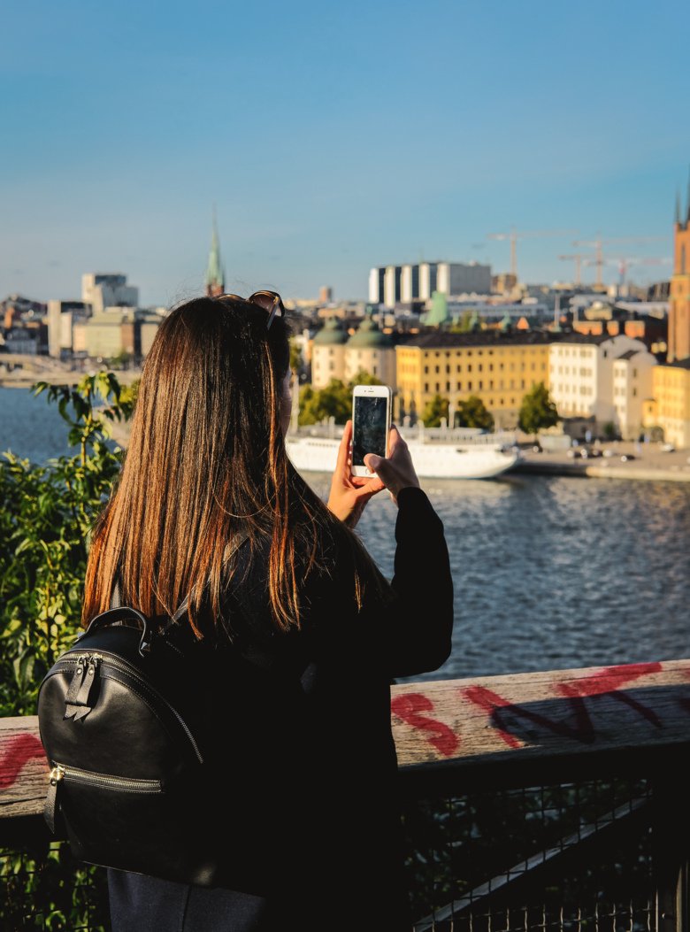 A student takes a photo of the Stockholm skyline with her phone.