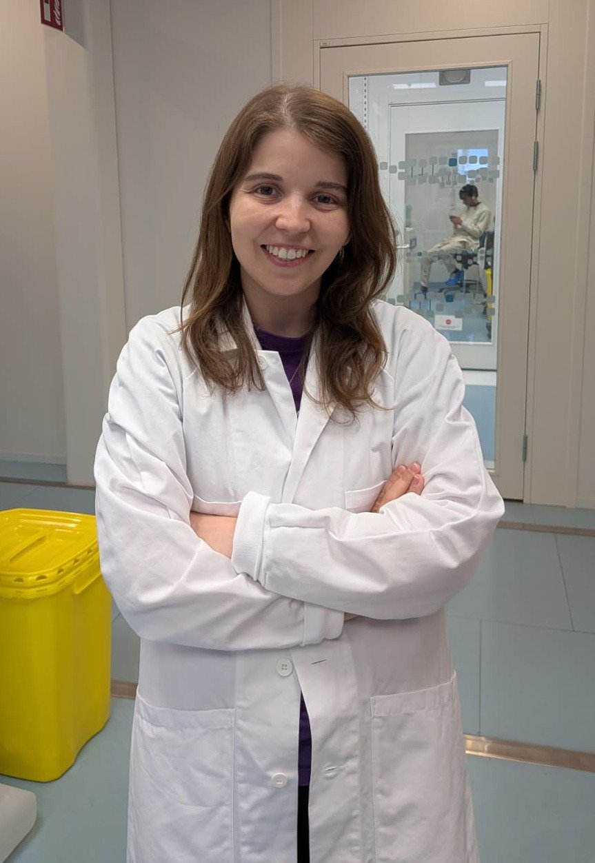 Portrait of a smiling woman wearing a lab coat. In a laboratory setting.