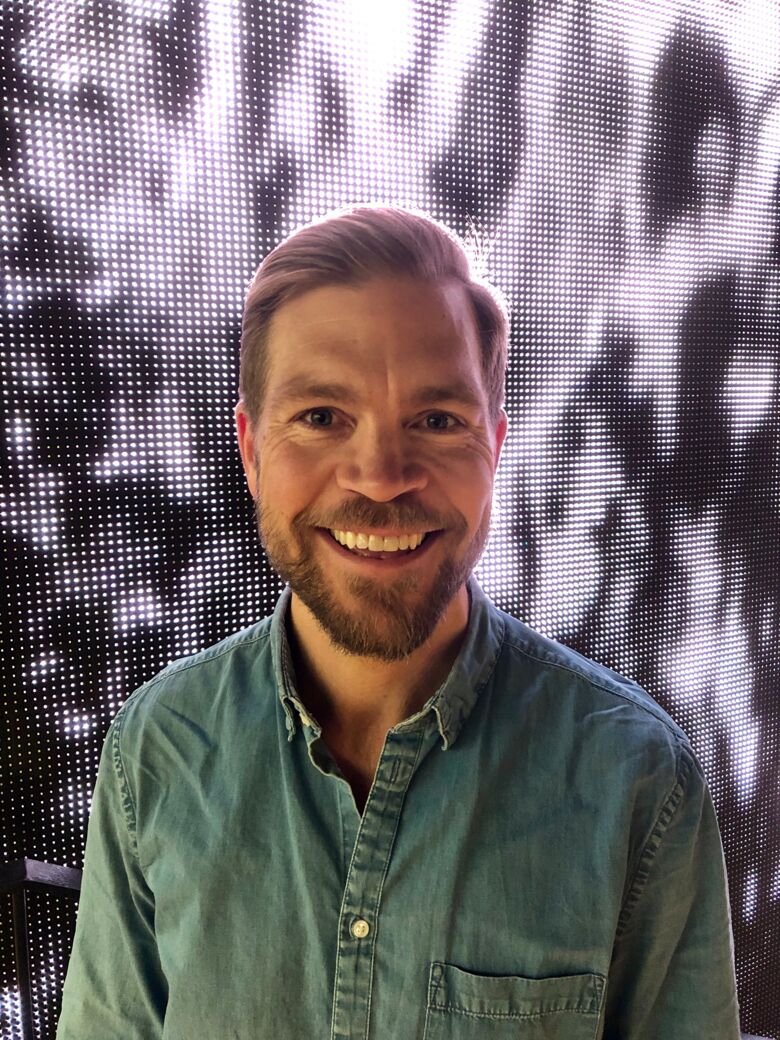 Lars Karlsson in front of a digital waterfall.