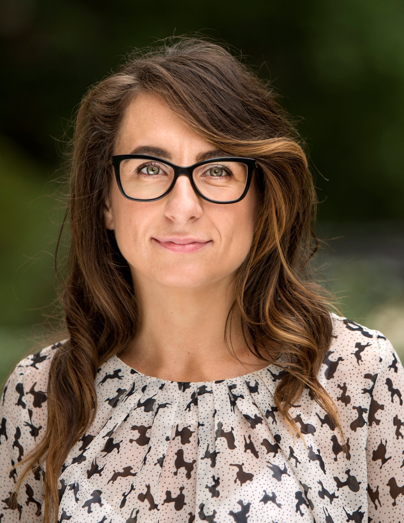 Portrait of a women with dark hair and glasses.