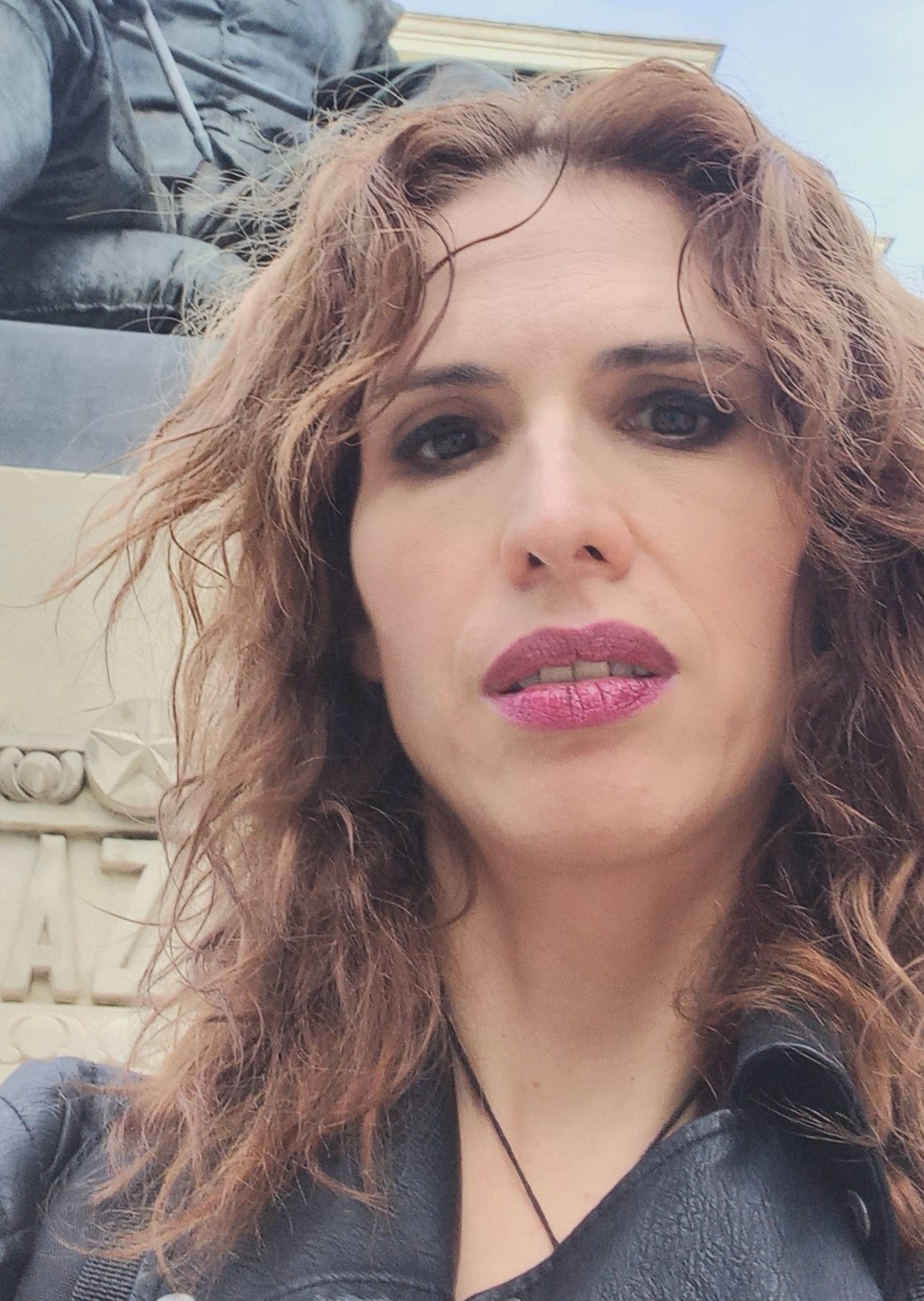 Portrait photo of a woman with brown, curly hair.