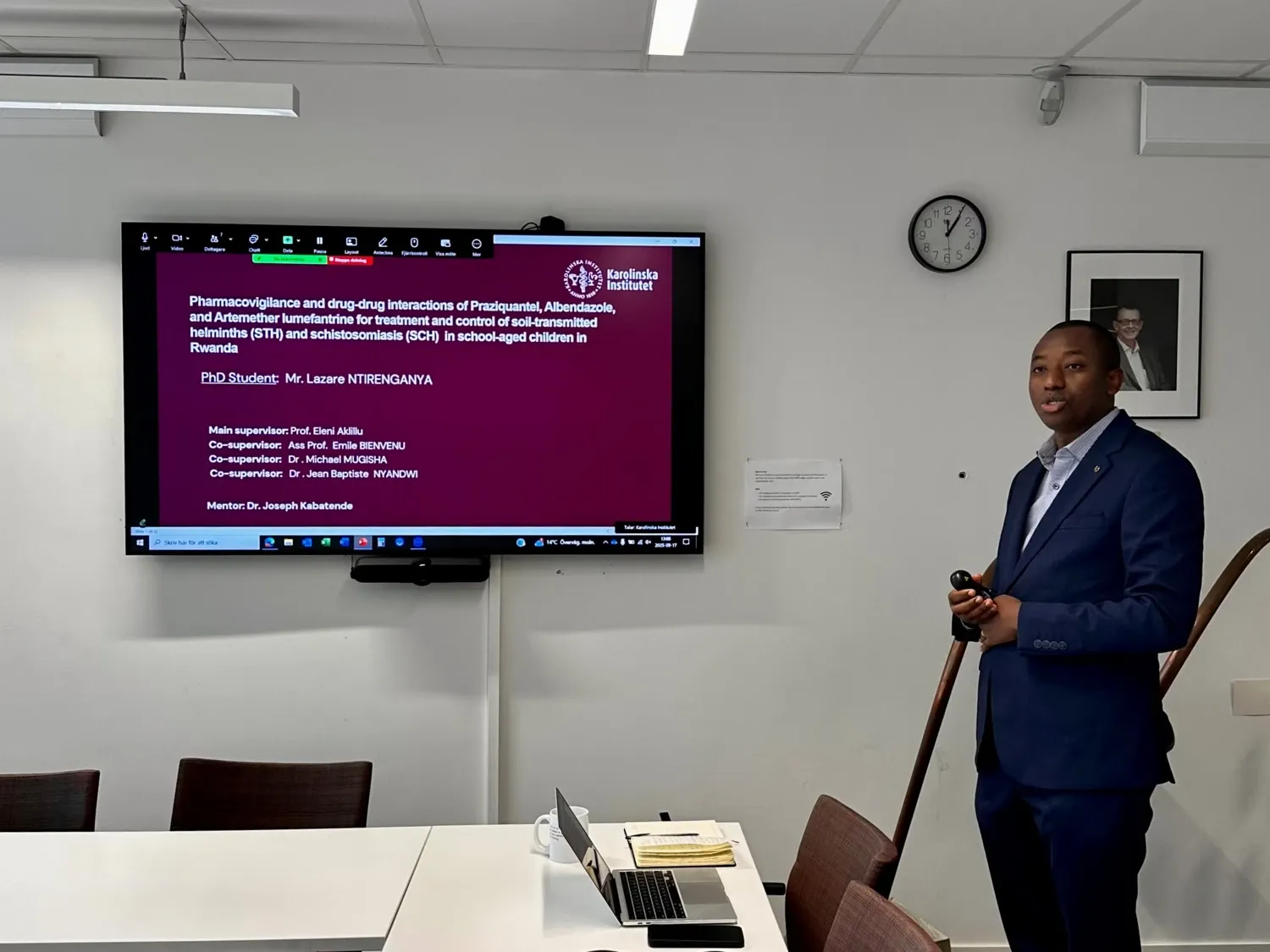 Man standing in front of a large screen, giving a presentation.