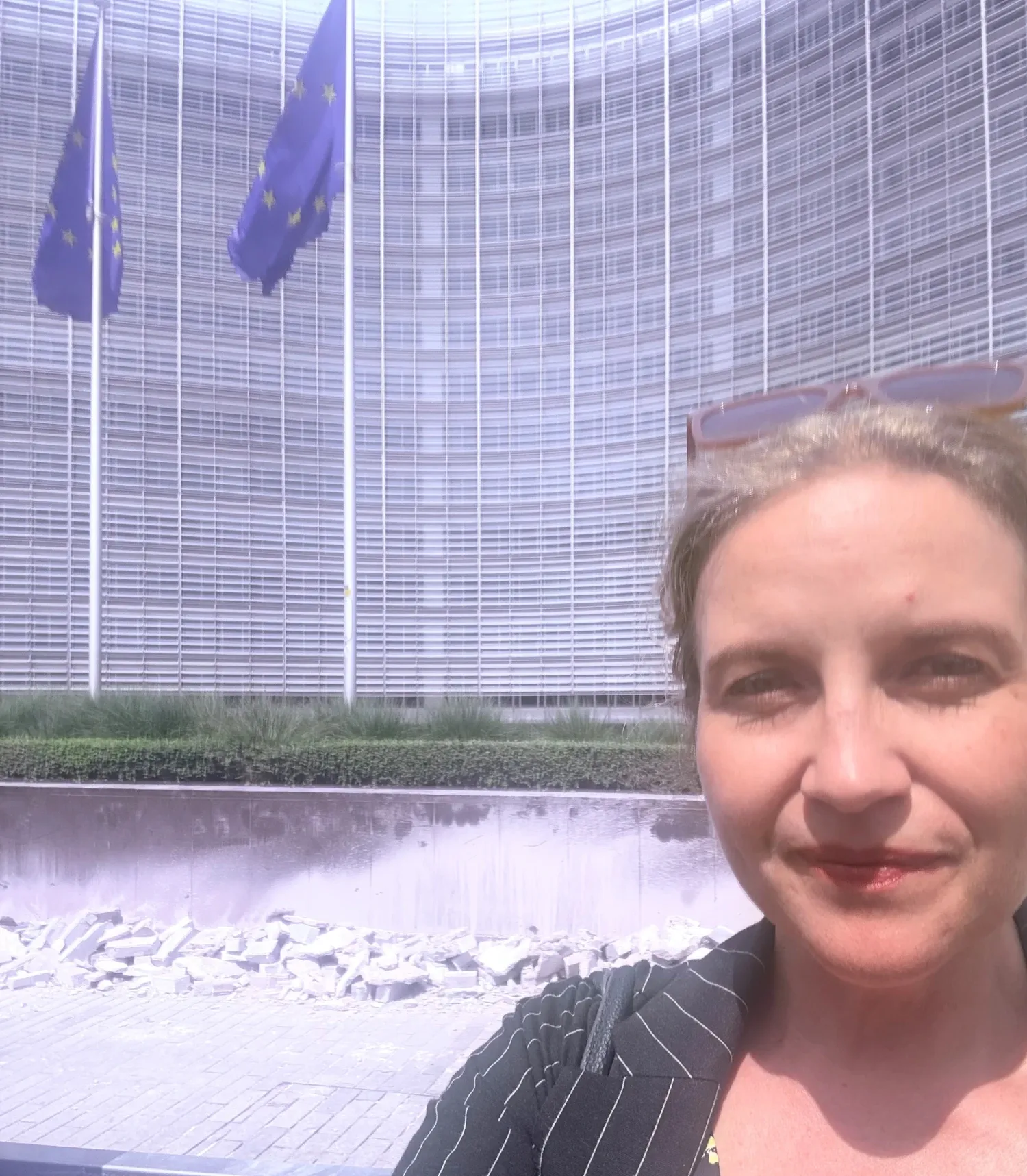 En kvinna står framför en byggnad med EU-flaggor framför oss