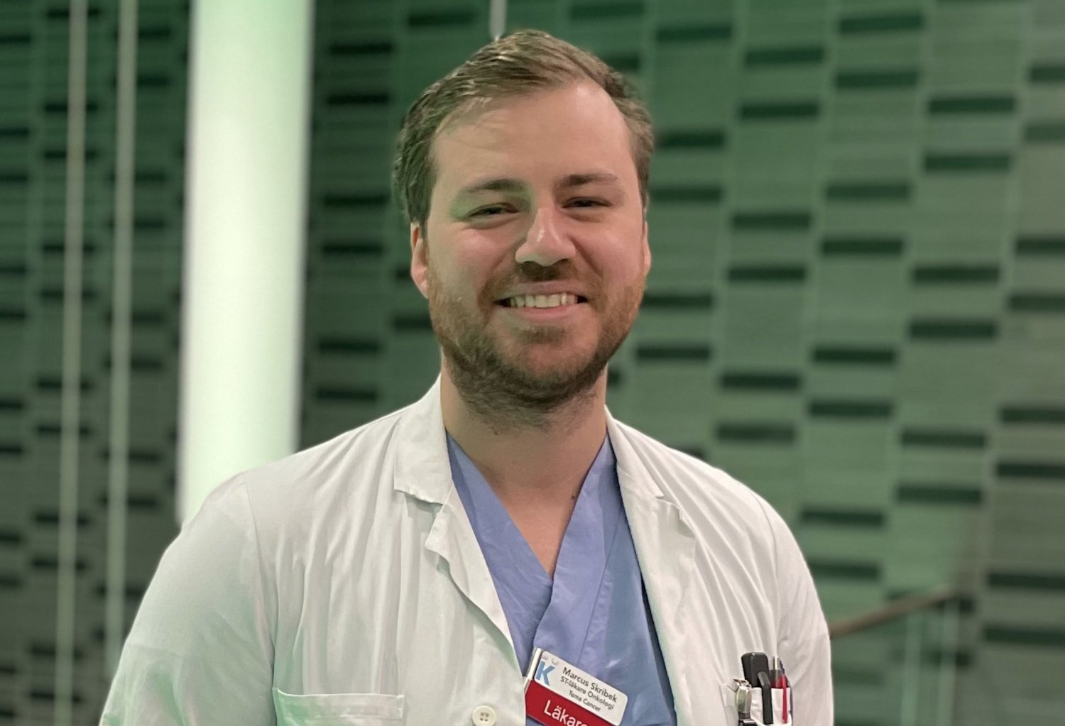 Portrait of Marcus Skribek in blue and white scrubs.