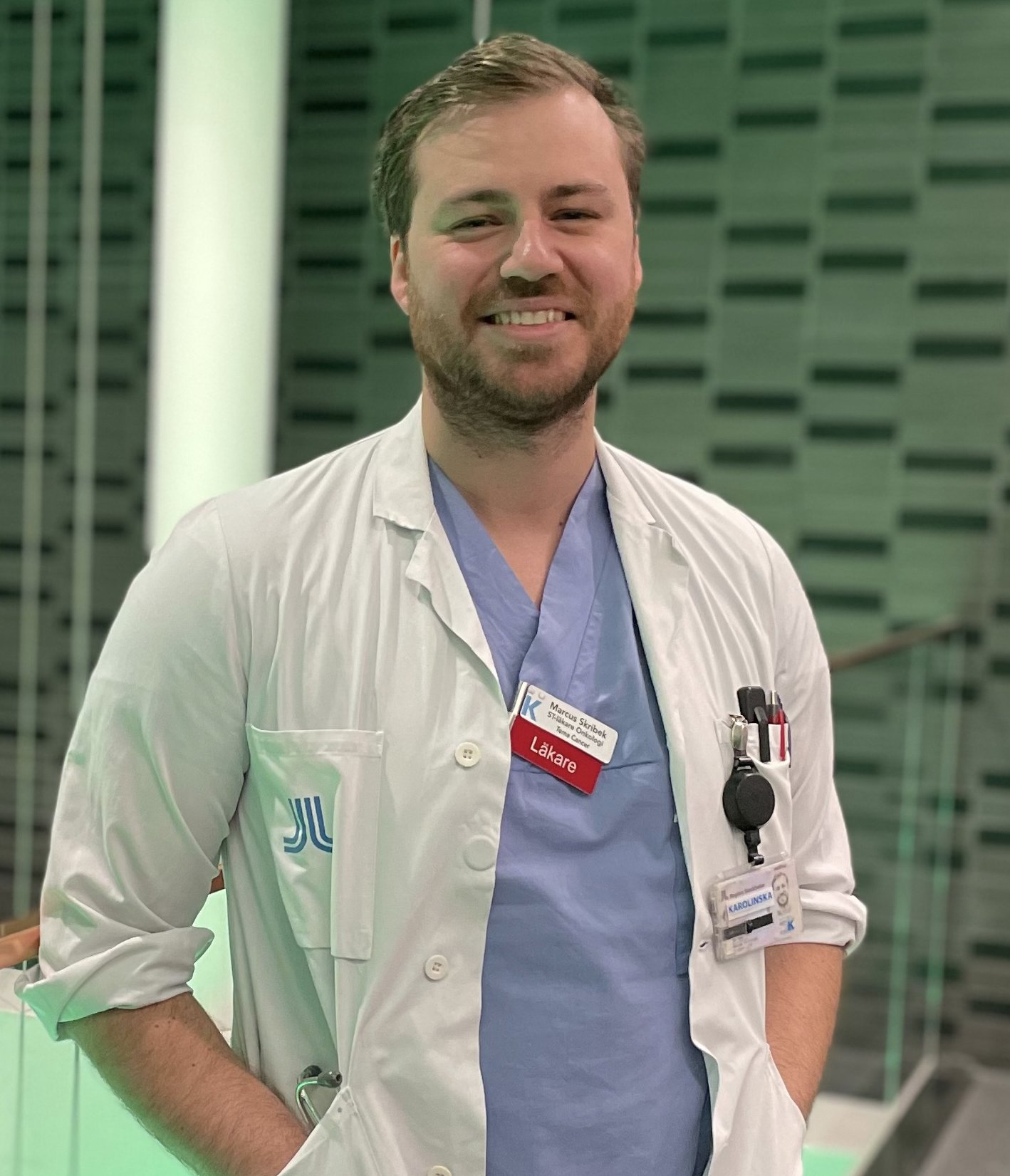 Portrait of Marcus Skribek in blue and white scrubs.