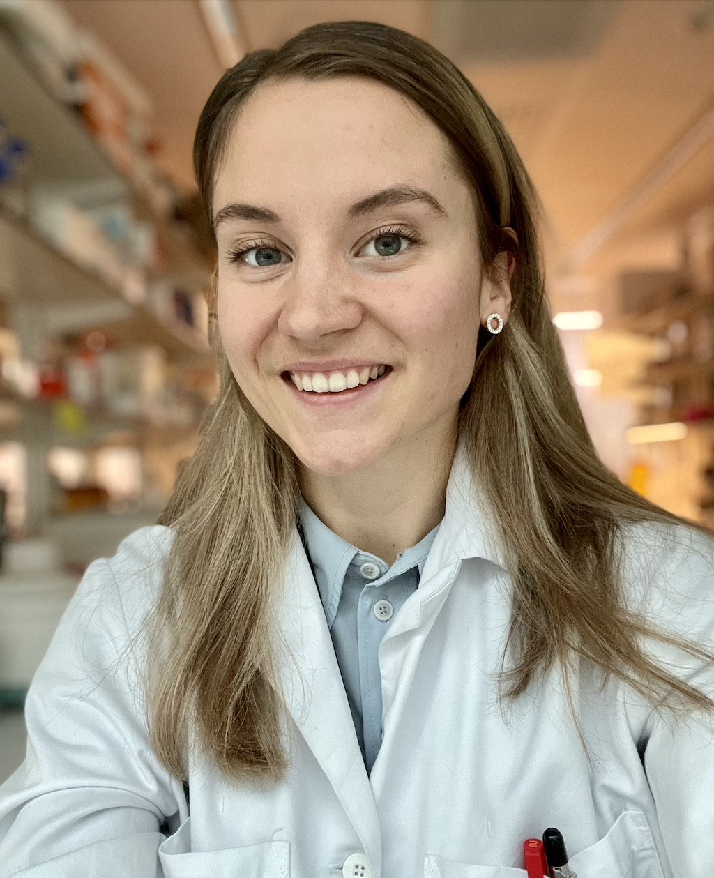 Woman smiling in a laboratory setting.