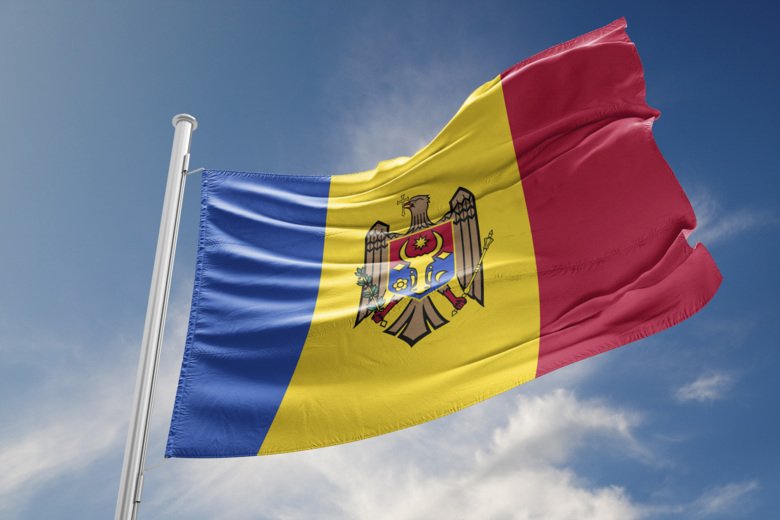 The national flag of Moldova on a flag pole against a blue sky