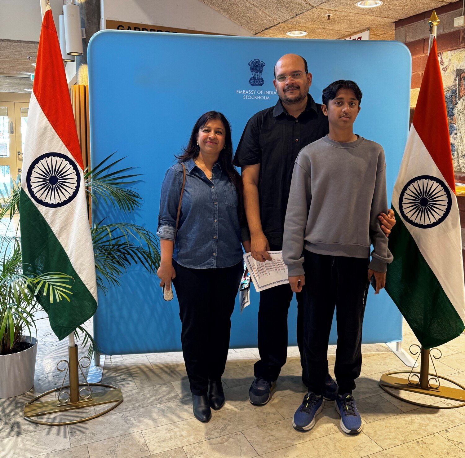 three persons in front of a flag