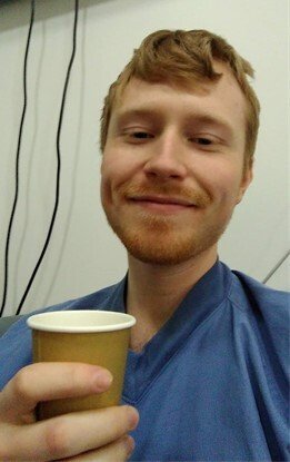 Oscar at a coffee break during a work shift at IVA with blue scruba with a coffee cup