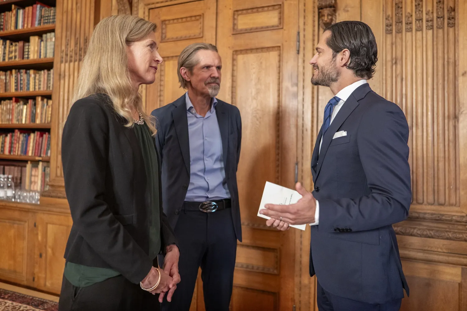 Photo of a woman and two men talking