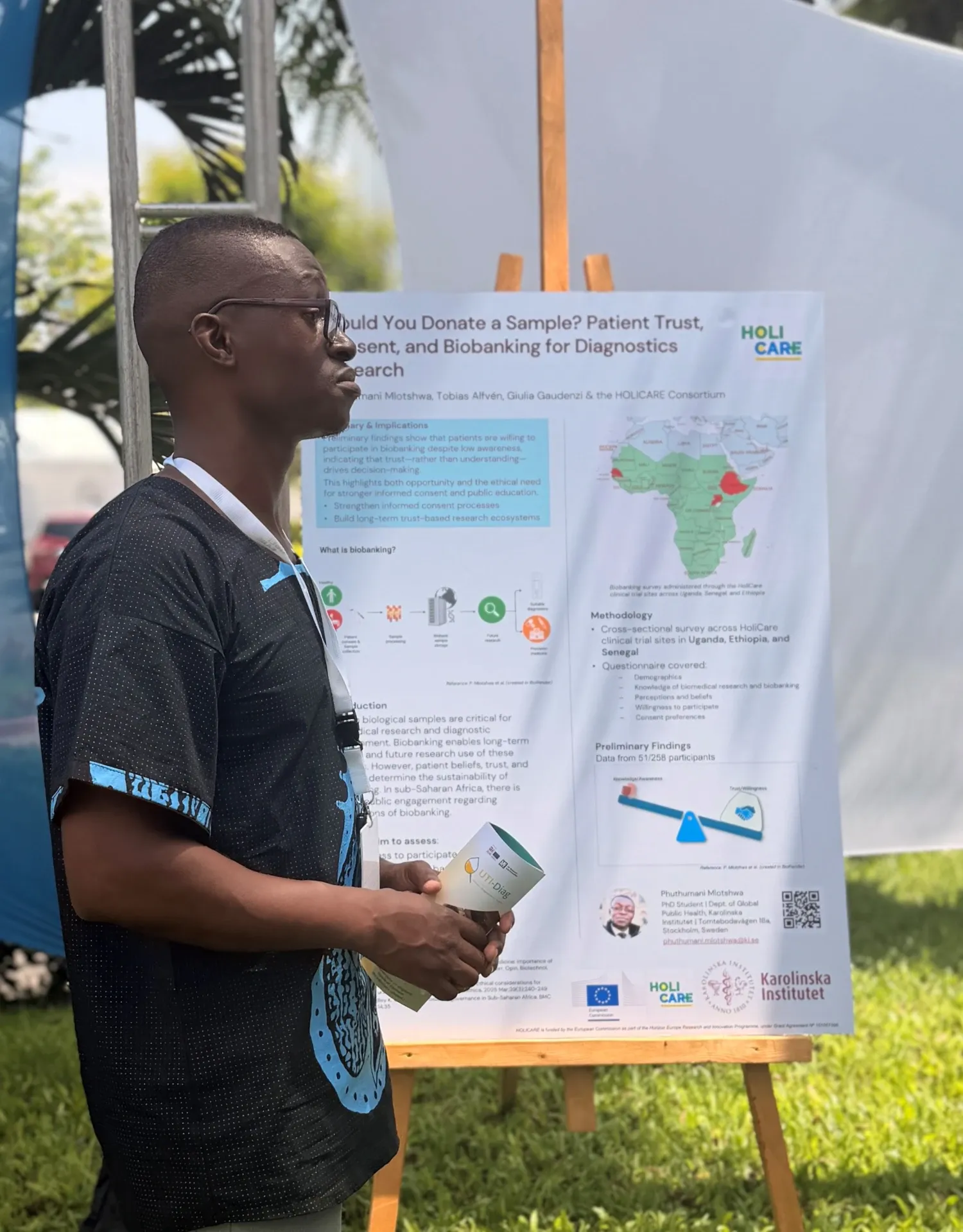 A man standing in front of his poster during a poster session.