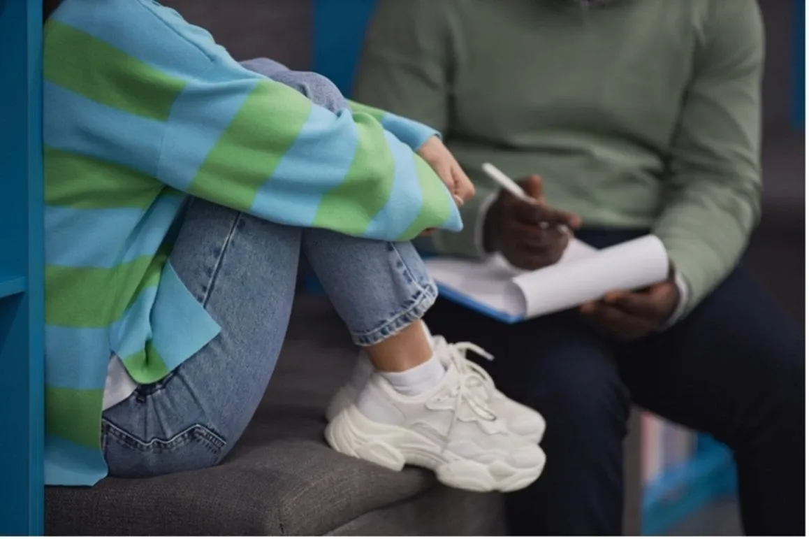 child talking to adult who is taking notes