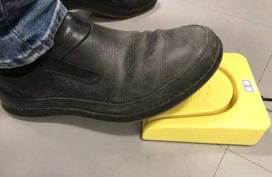 A foot steps on a foot pedal unit.