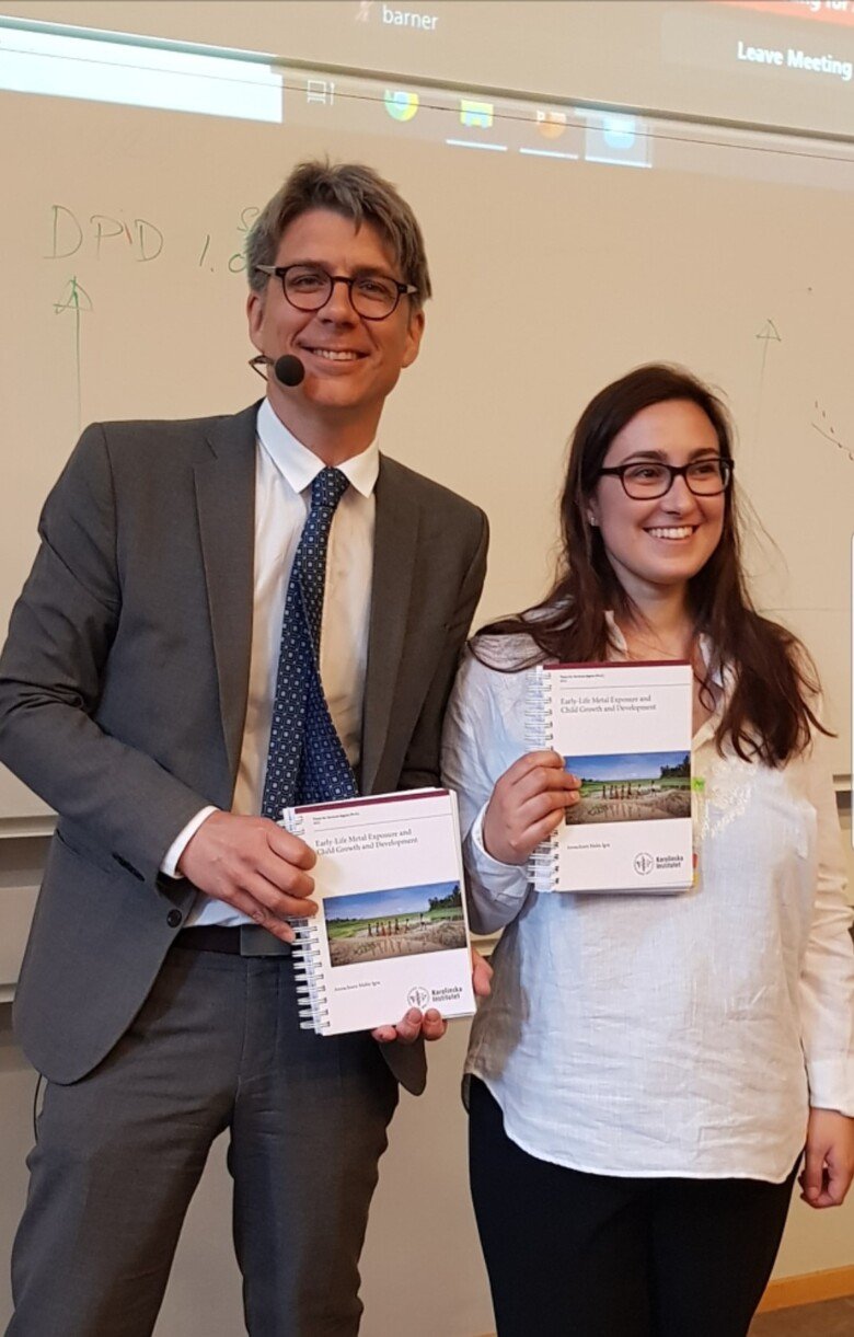 Picture of opponent Tobias Alfvén and Annachiara Malin Igra at her PhD dissertation in June, 2022. Tobias is holding up the dissertation in his hand.