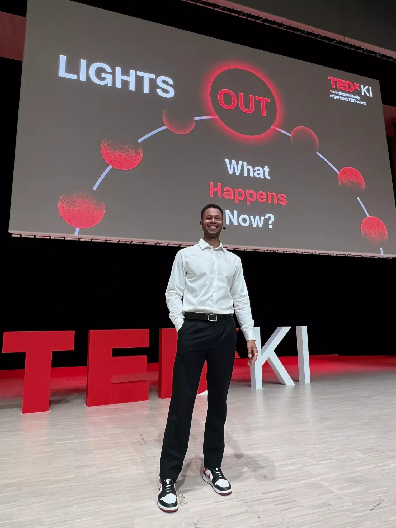 KI student Tade on stage during a TEDxKI event.
