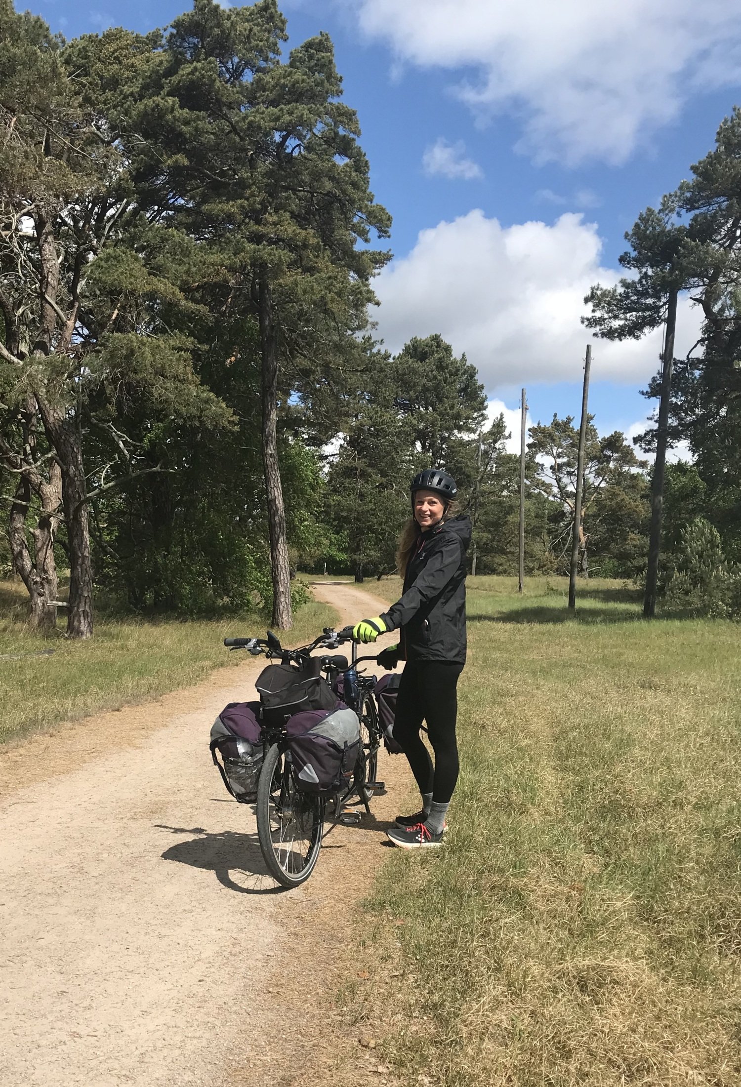 Pernilla Alencar Siljehag holds the tandem bike and stands on a gravel road.