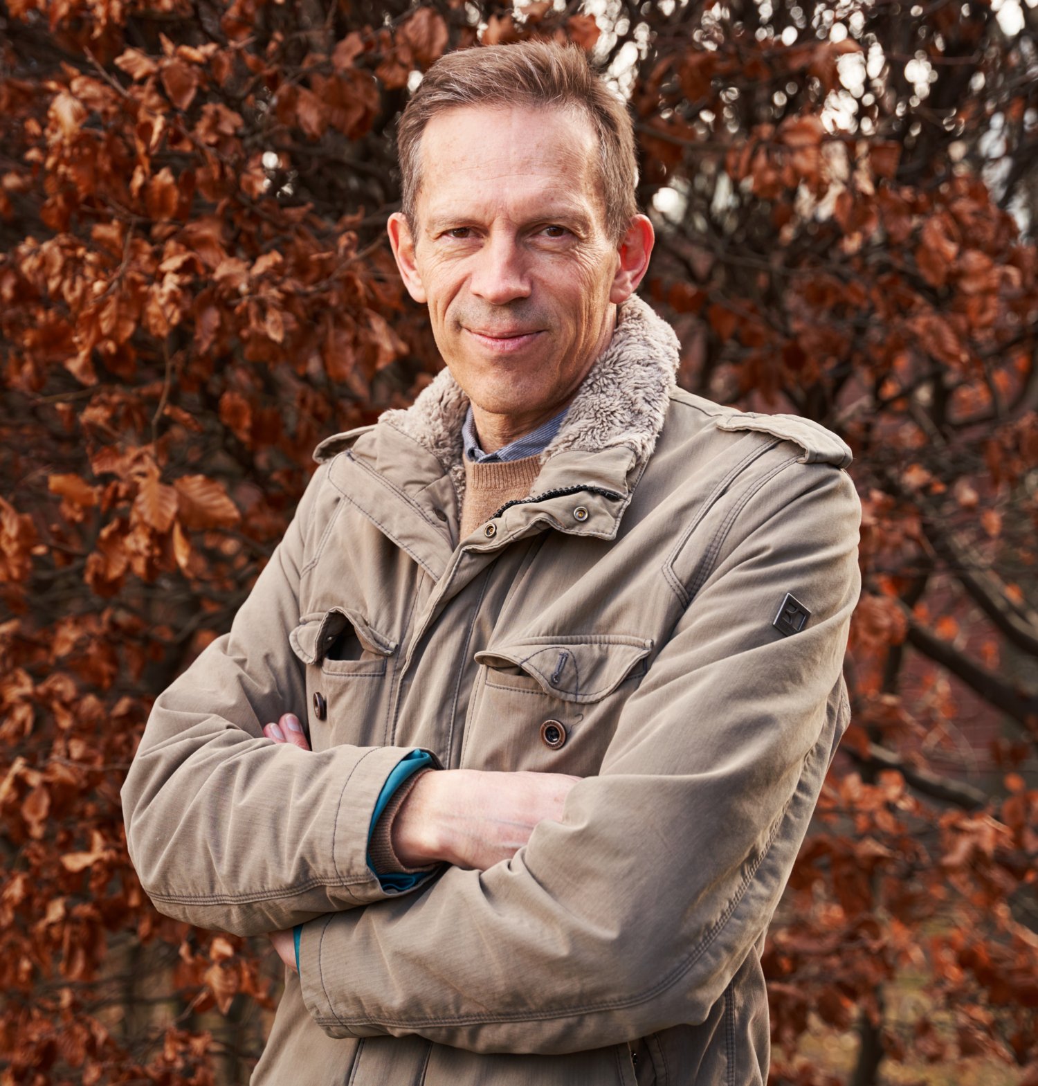Thomas Perlmann outdoors, in front of a colorful deciduous tree.