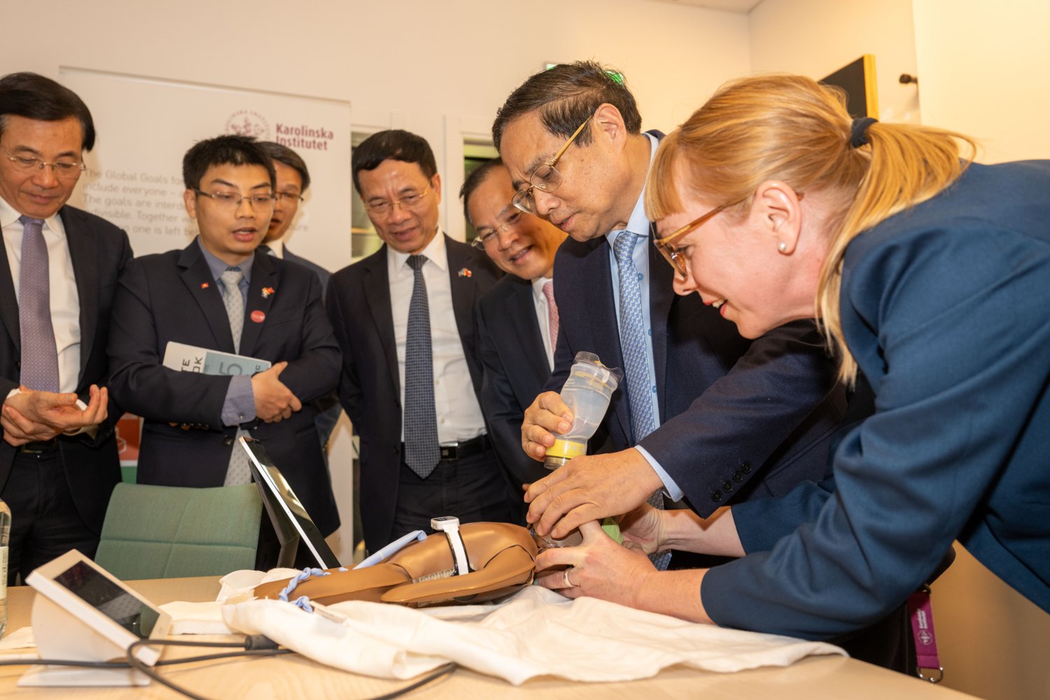 Vietnamese Prime Minister Pham Minh Chinh tries out the teaching materials for teaching CPR to newborns with the help of Susanna Myrnerts Höök.
