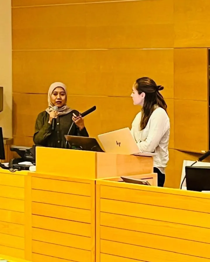 Two women, Wurry Ayuningtyas and Alma Nordenstam stand by a podium and give a presentation..