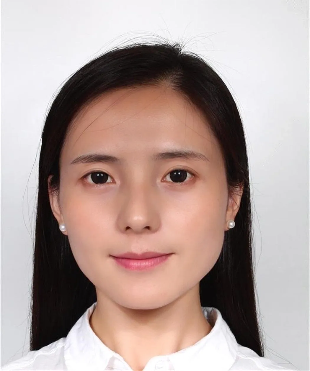 Portrait of a woman with dark hair, wearing a white shirt.