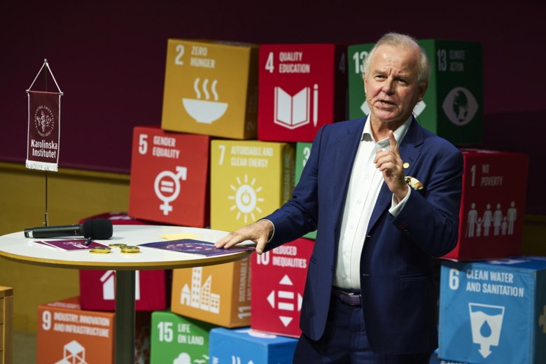 Ole Petter Ottersen speaking and lifting a finger. UN's sustainable development goals in background.