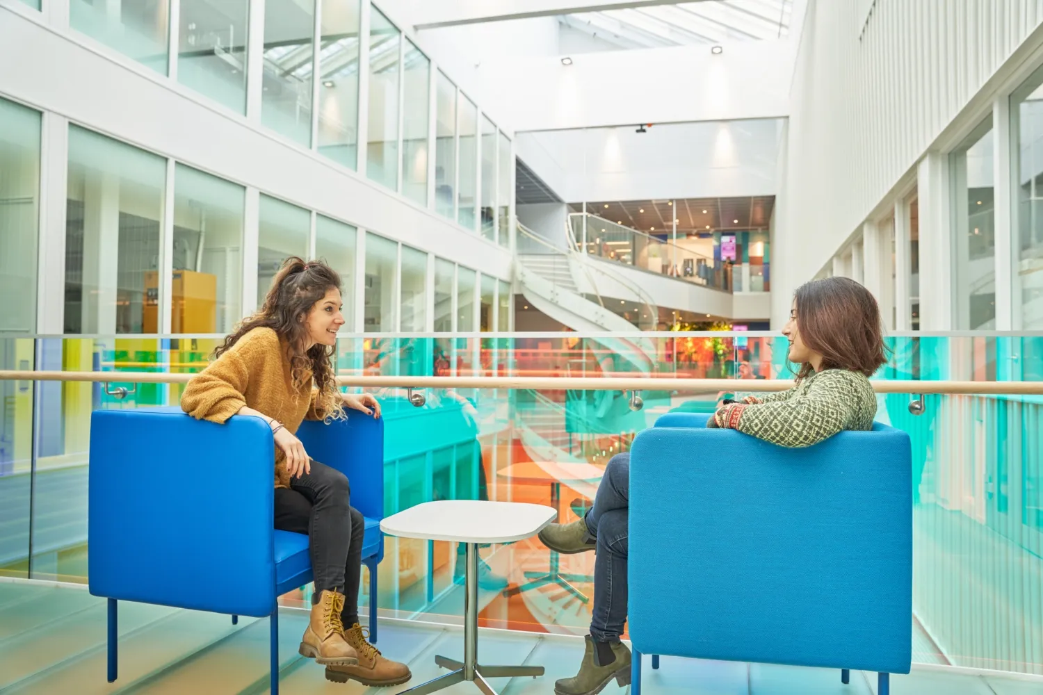 Two people sitting in armchairs opposite each other and talk.