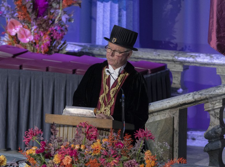 President Ole Petter Ottersen in his doctoral hat, standing on stage facing the crowd.
