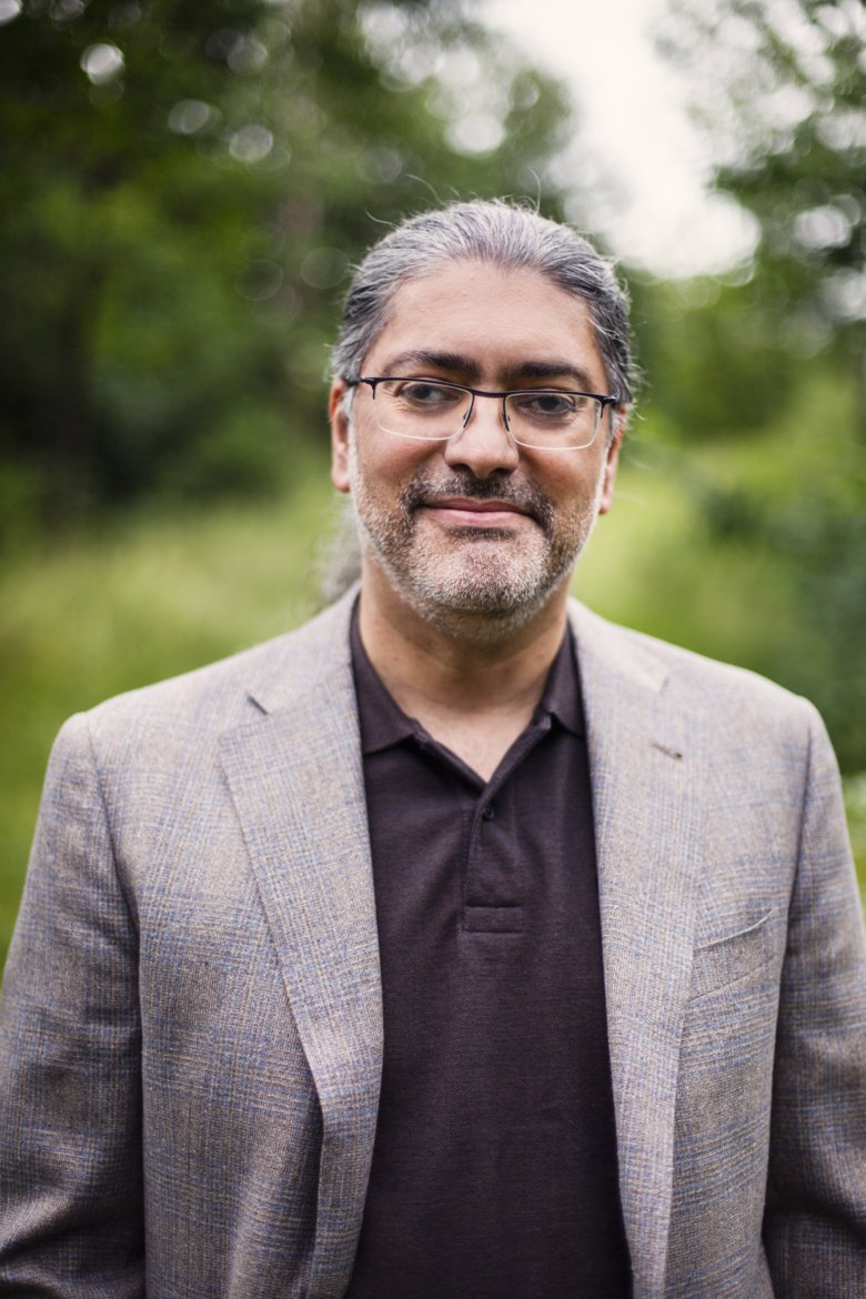 Portrait of Ali Mirazimi outdoors in a park.