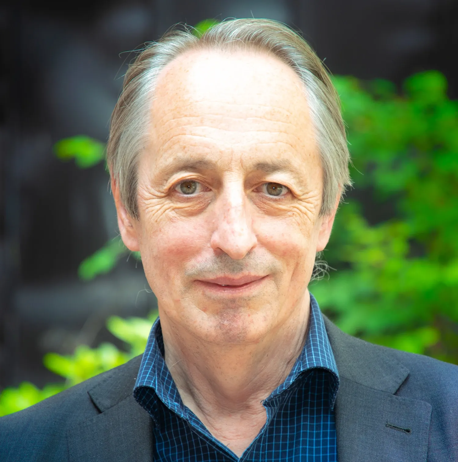 A picture of lecturer Andrew Hennigan with green plants in the background.