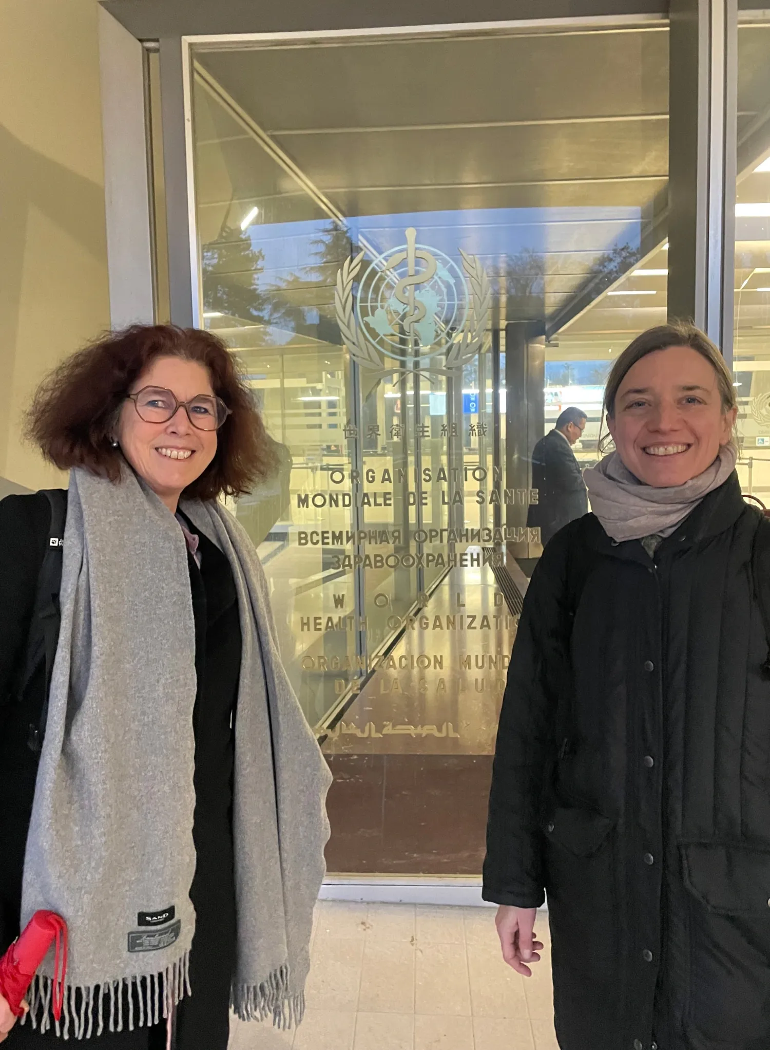 Claudia Hanson and Elin Larsson standing in front of the entrance to the meeting hall.