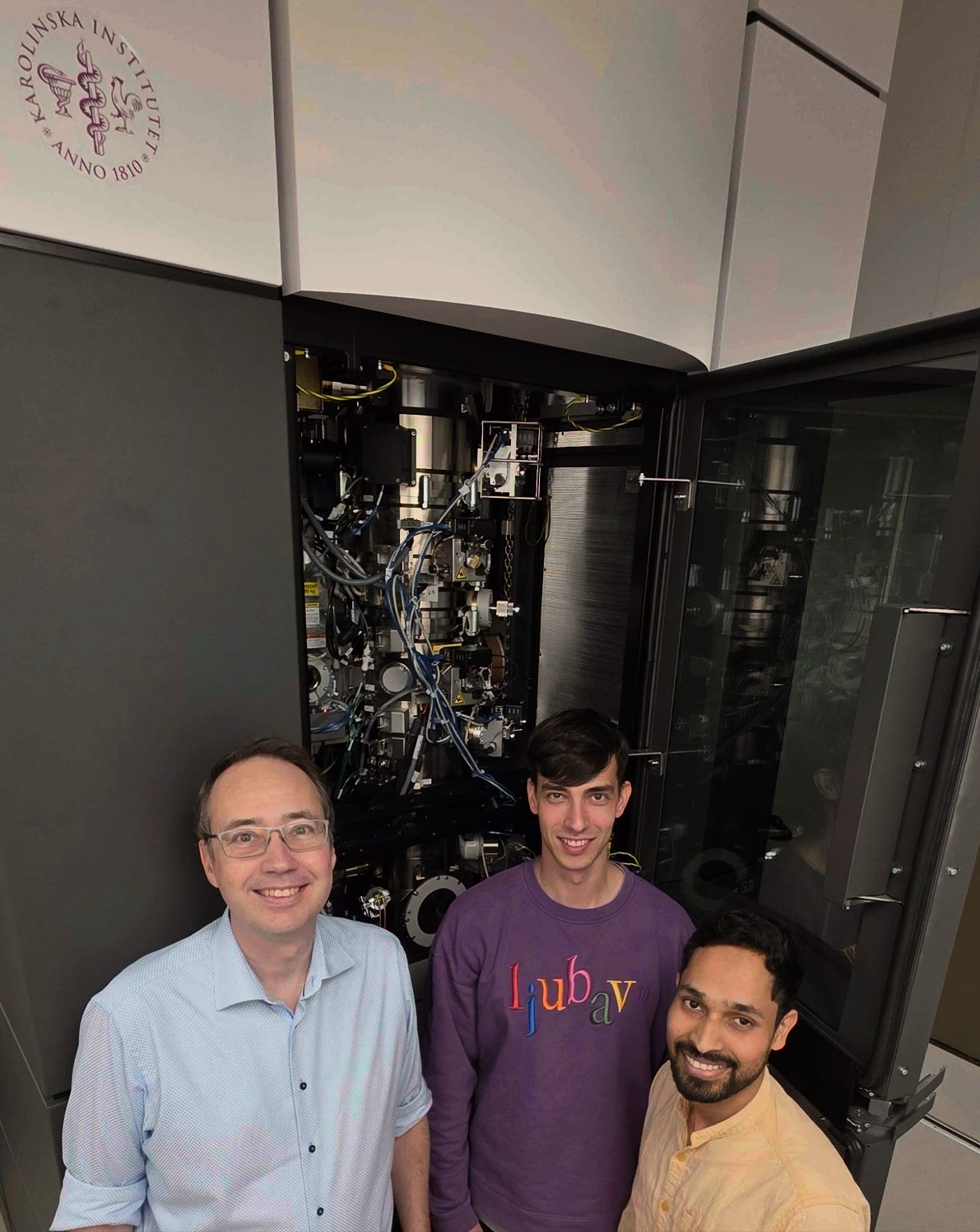 Three men standing in front of a big machine.