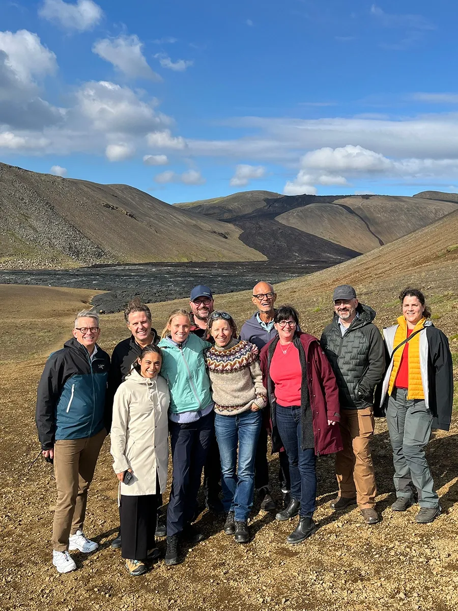 A group of people standing at a lava field.