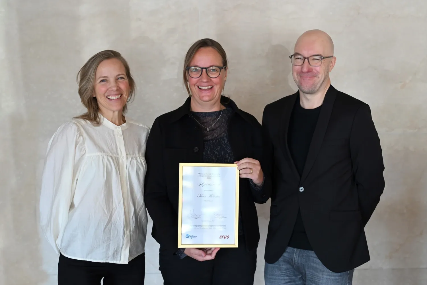 Karin Söderkvist, Karin Holmsten and Johannes Arpegard stands next to each other. Karin Holmsten in the middle is holding a diploma.