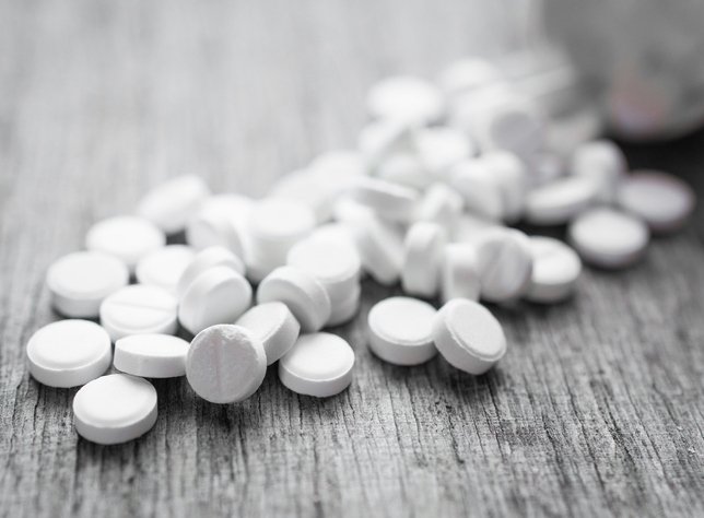 white pills on a wooden table