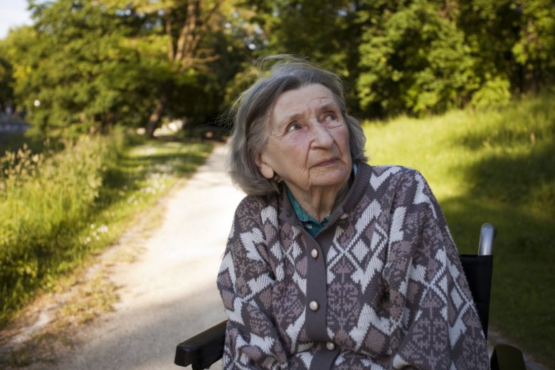 Photo of elderly woman in wheelchair in park.