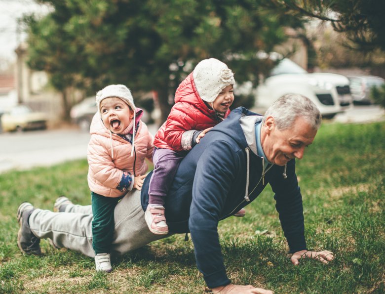 Grandfather and granddaughters playing in the park