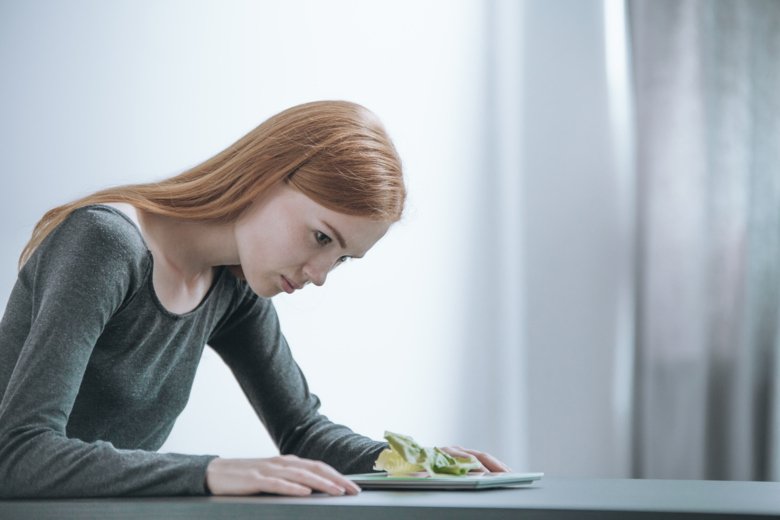 Photo of young woman weighing her food.