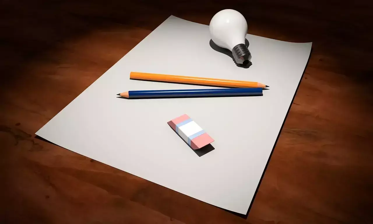 A picture of a blank sheet of paper with two penciles, an eraser and a bulb.
