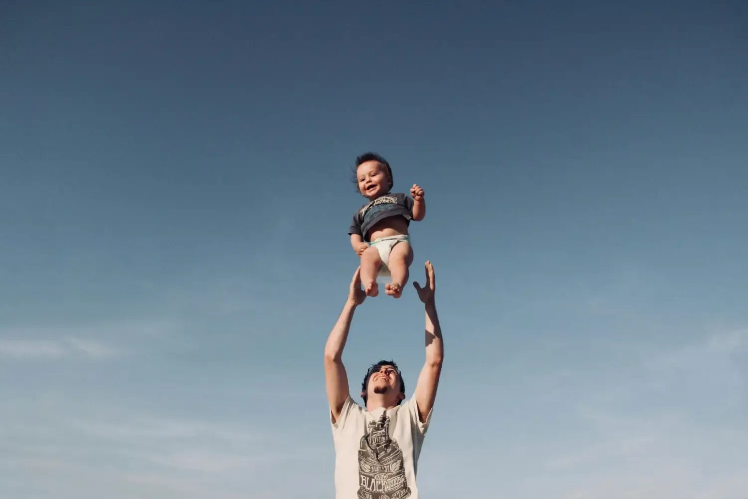 Father throwing baby in the air