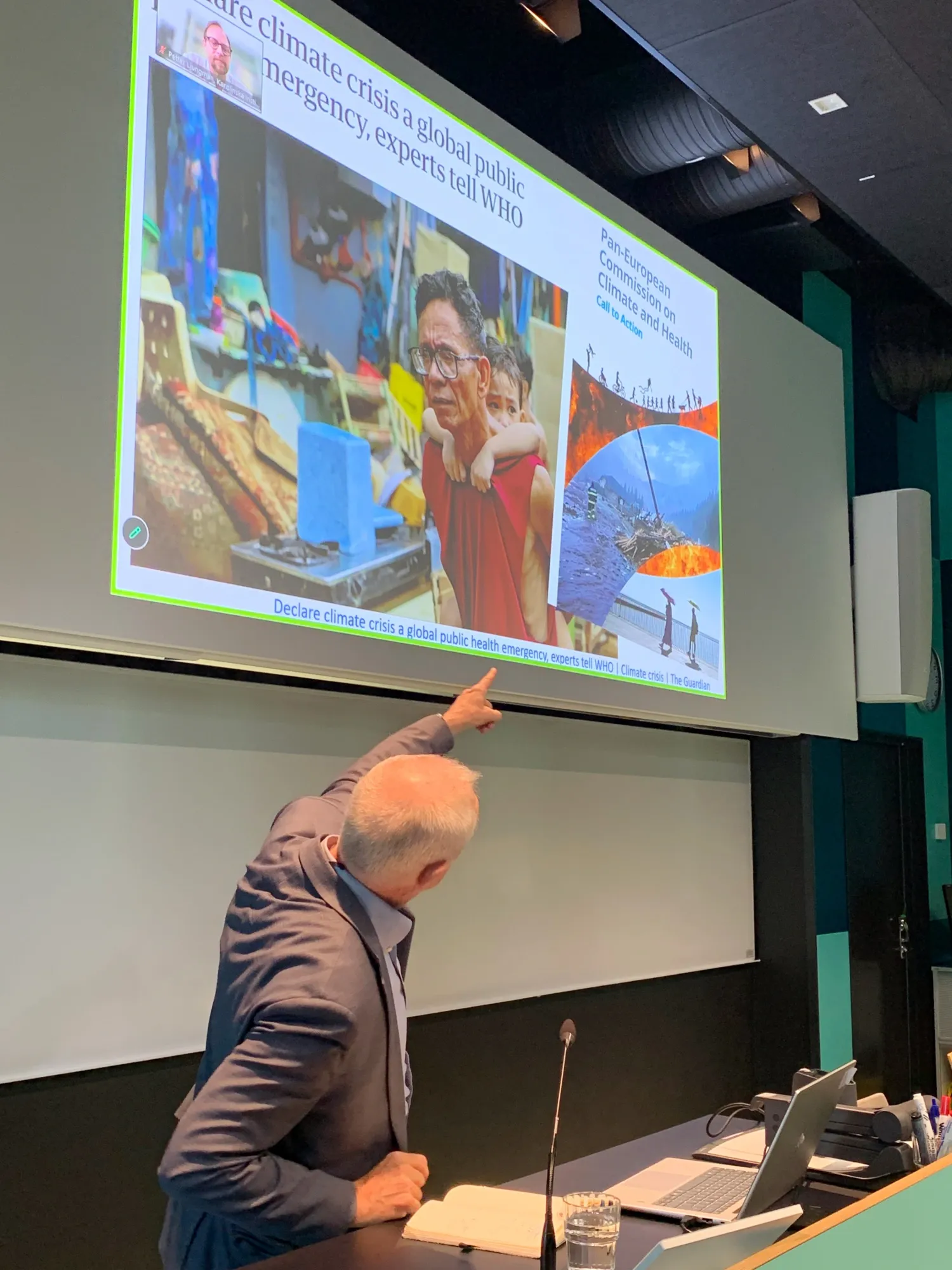 Stefan Swartling Peterson is standing at a lectern, showing a slide that illustrates the impact of climate change on health through examples.