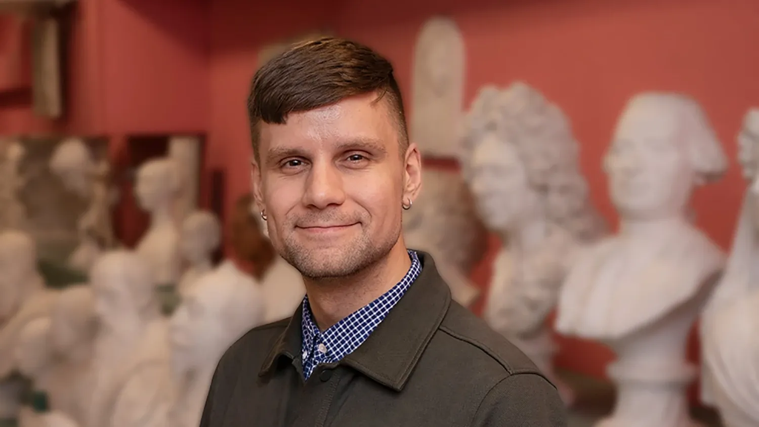 Man in front of sculpural busts.