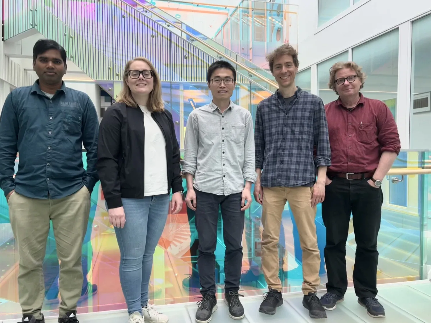 Group photo of five people. Four men and one female.