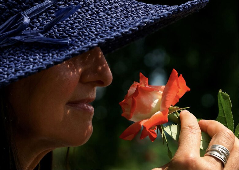 Woman in profile smelling a flower