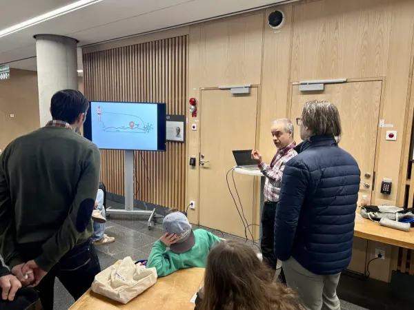 People listening to an explanation, with images displayed on a screen.