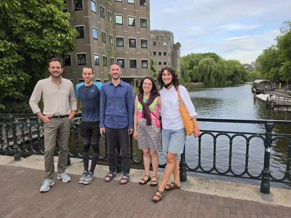 Five persons on a bridge over Amsterdam's canals.
