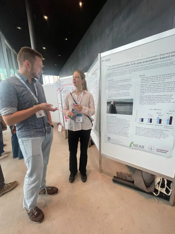 Linnea Sjöberg att the poster wall discussing with another participant at the congress.