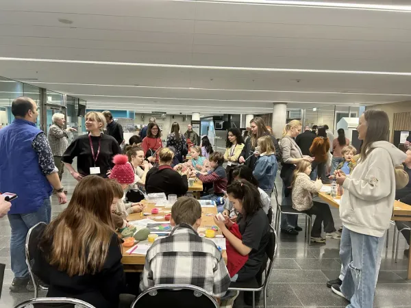 People standing or sitting, taking part in hands-on activities.