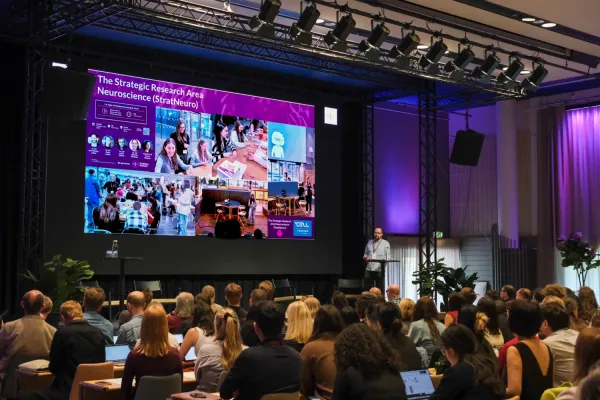 People attending a conference, with someone on stage