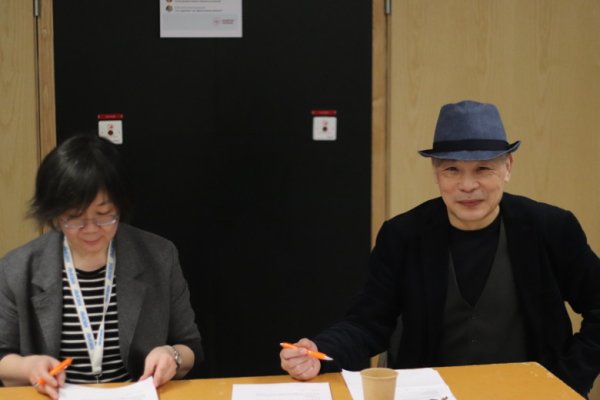 Hong Xu and Yuxi Zhou sitting at a table preparing memory tests for visitors to perform.
